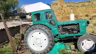 Трактор с кабиной, окрашен в зелёный цвет с белой крышей. Колёсная